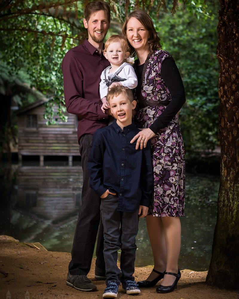 A family photographed together with their dog in the garden