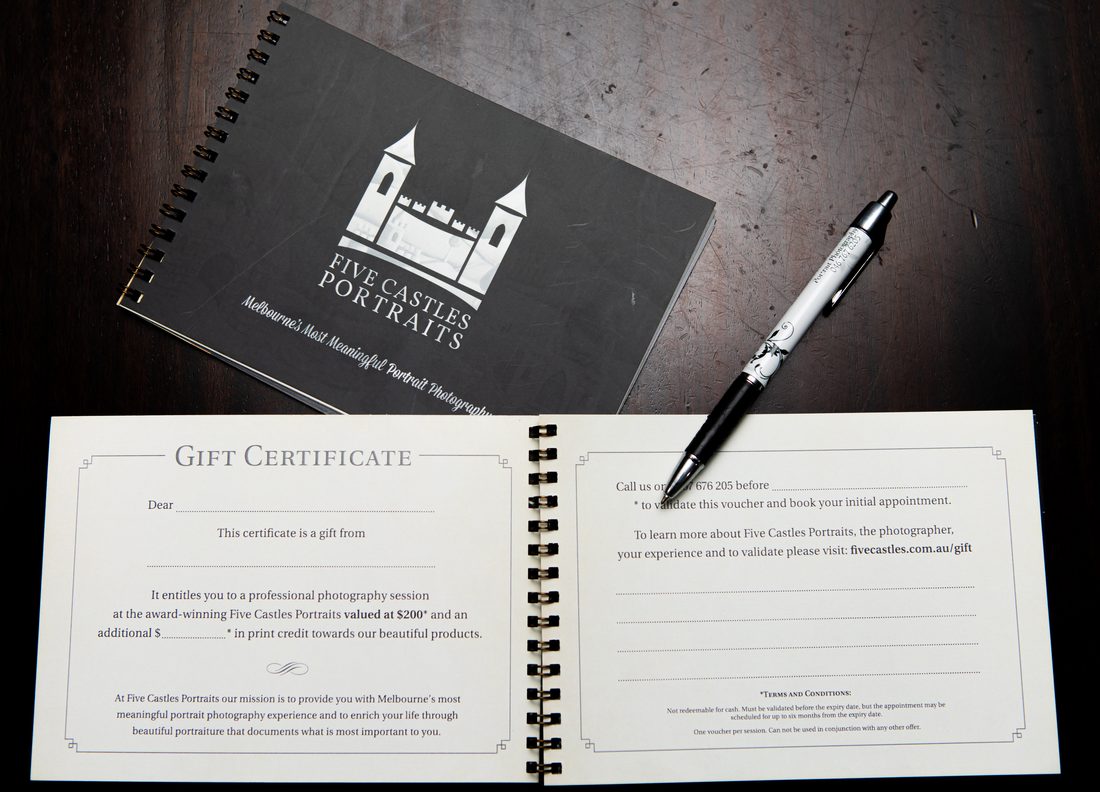 A Five Castles Portraits gift certificate booklet, open on a black table
