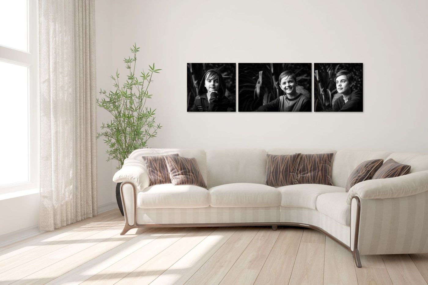 Three portraits displayed together above a loungeroom sofa