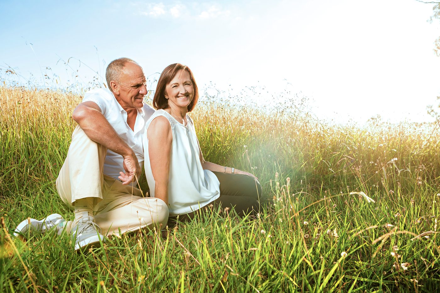 An older couple standing together in a field during golden hour