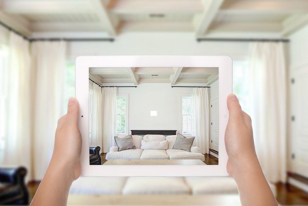 Photographing a loungeroom wall on a tablet to plan where the portrait artwork will be displayed