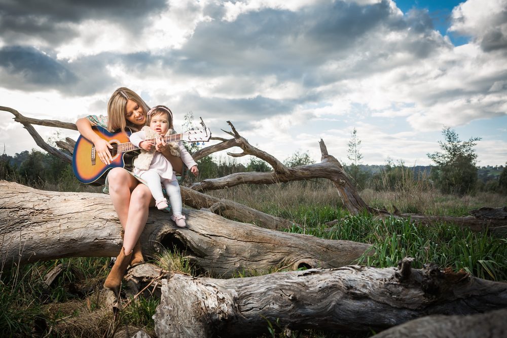 A mother and daughter walking through golden light at their portrait session