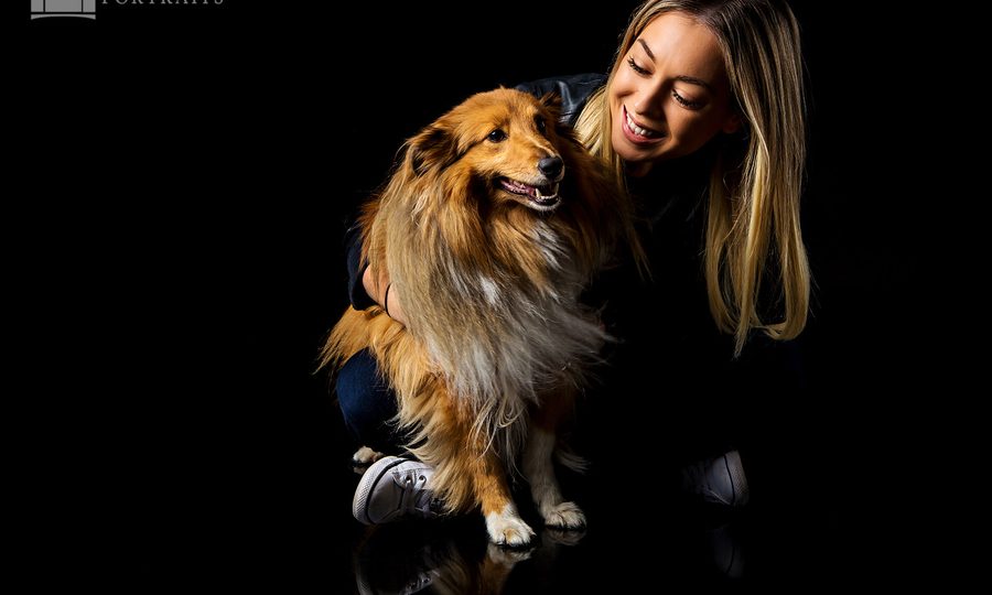 Woman with a large golden dog in a colour studio portrait