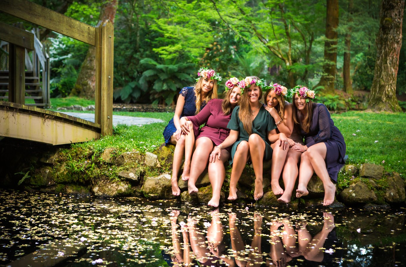 Six young women at woodland pond with water reflection