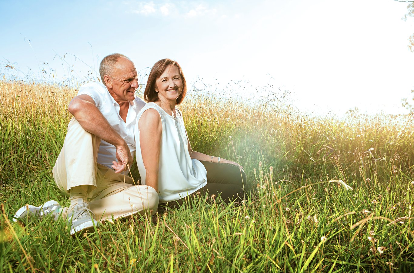 Older couple in field during golden hour, tender and timeless