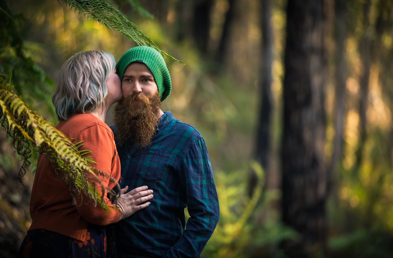 Aerial overhead perspective of couple lying in dry grass; playful and tender with fresh compositional perspective